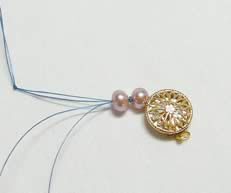 Two beads and a clasp strung onto a thread